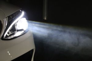 Headlight beams on a white car.